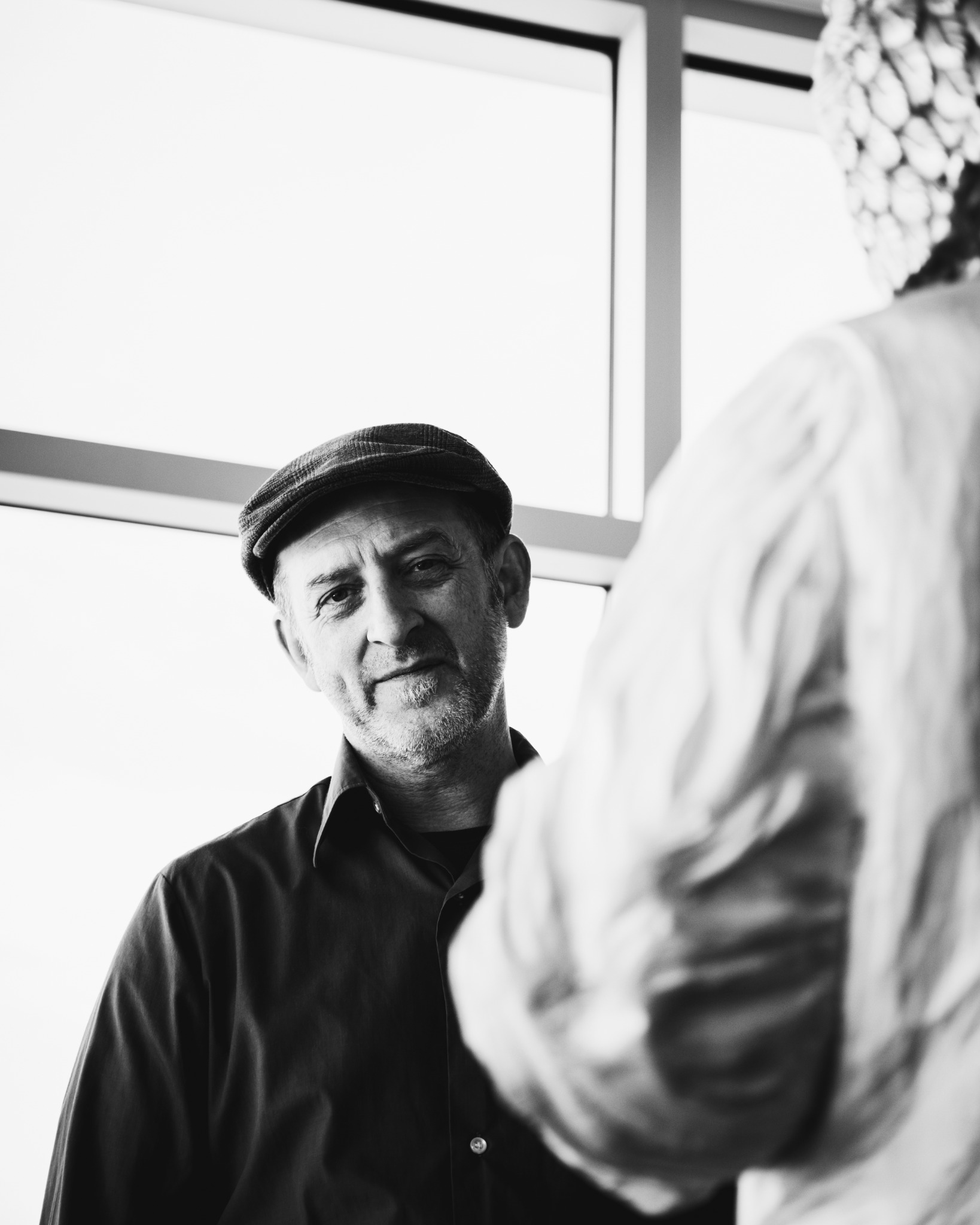 Portrait en noir et blanc de Jean-Robert Drouillard devant une sculpture.